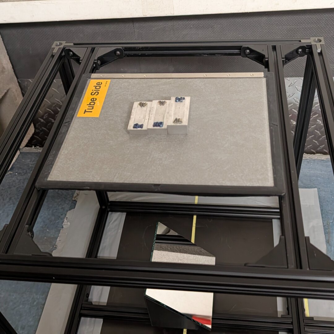 Aperture imaging cage with IQI plaque on step-wedge